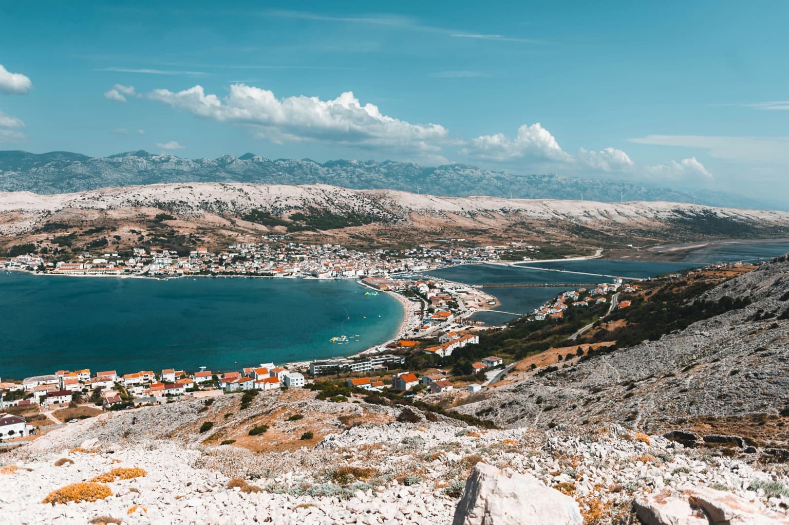 Wide view across Pag town, its bay and pale rocky landscape